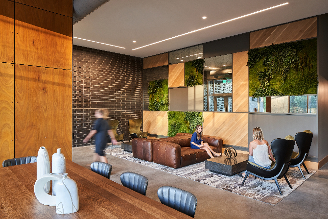 Peace Raleigh sitting area features oversized leather seating a combination of brick and wood walls with subtle greenery features.