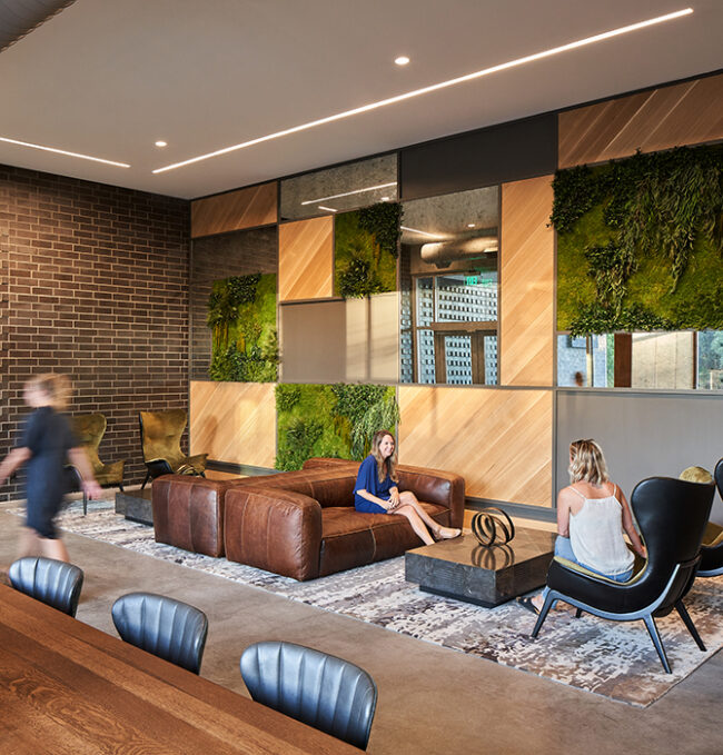Peace Raleigh sitting area features oversized leather seating a combination of brick and wood walls with subtle greenery features.