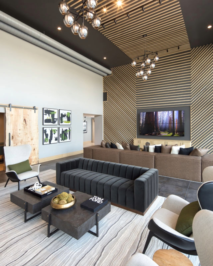 Club area living room with wood slatted feature wall, modern oversized seating, and ceiling lighting detail