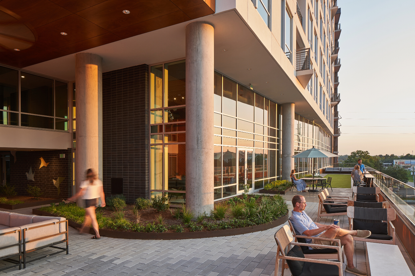 Peace Apartments outdoor overlook at dusk, people sitting outside looking at skyline