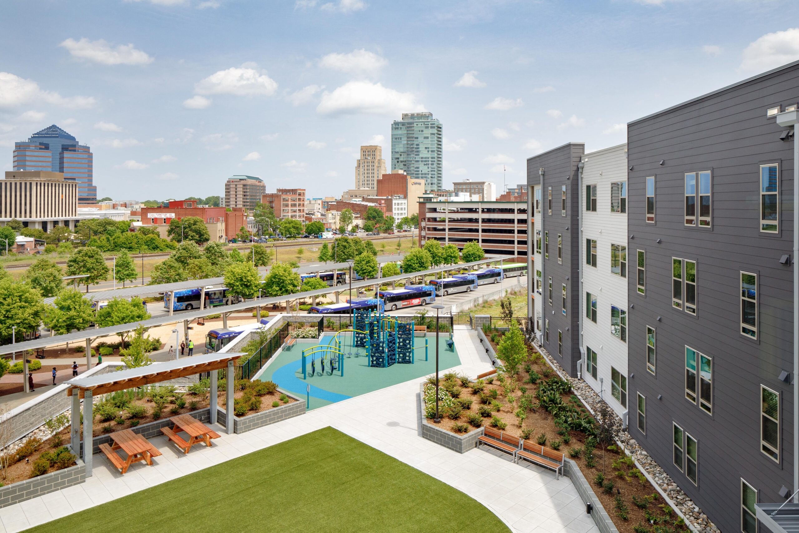 Outdoor play area and gathering spaces overlooking bus transfer station